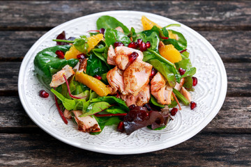 Fresh Salmon Salad with vegetables, pomegranate and orange.