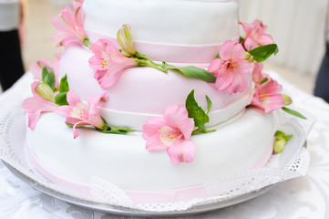 Fototapeta na wymiar Wedding Cake decorated with pink lily flowers