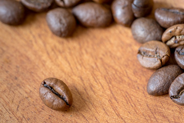 Detail view of coffee beans on wooden background. Macro shoot.