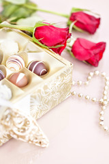 Chocolate truffles and red roses with copy space