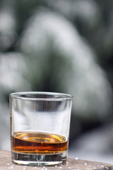 Whiskey glass on a table with a blurred, snow background