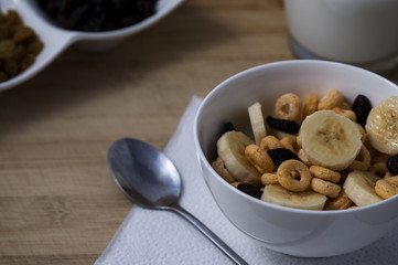 Plate with corn flakes and fruits on wooden background
