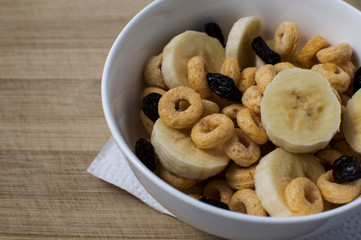 Plate with corn flakes and fruits on wooden background