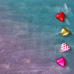 top view image of colorful heart shape chocolates on blackboard background. valentine's day...