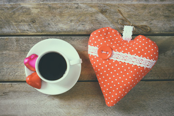 top view image of colorful heart shape chocolates, fabric heart and cup of coffee on wooden table. valentine's day celebration concept
