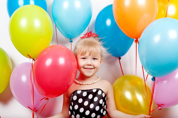 Fototapeta na wymiar Pretty little girl with colorful balloons on white background