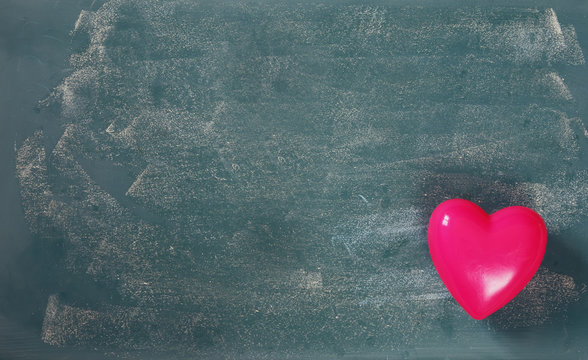 top view image of pink plastic heart on blackboard background. valentine's day celebration concept
