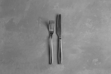 Fork and knife on the concrete background