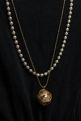 Pendant with pearls on a black background