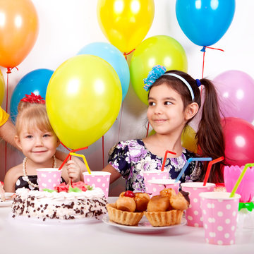 beautiful happy children with balloons and a cake at the children's birthday party