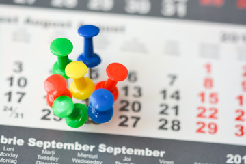 Multiple pins on a calendar suggesting busy day or schedule