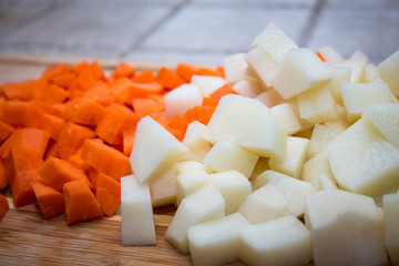 carrots and potatoes and the cutting board 