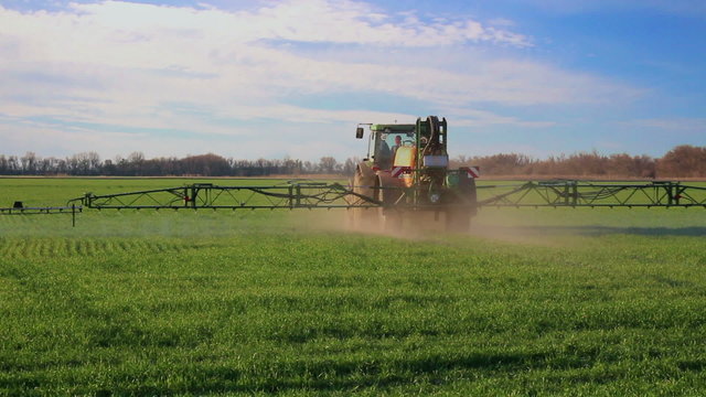 Tractor spraing the field with chemicals