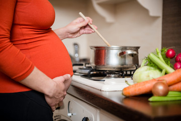 Pregnant woman cooking broccoli