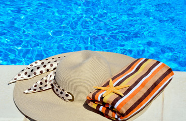 Woman beach hat, bright towel and starfish