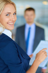 Businesswoman standing in office , holding documents in hand