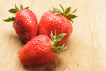 Red fresh strawberry fruits on wooden table.