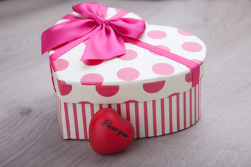 heart and gift on wooden background