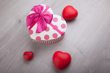 three hearts and gift on wooden background
