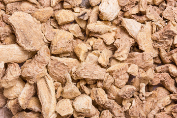 Ginger chopped dry pieces background.