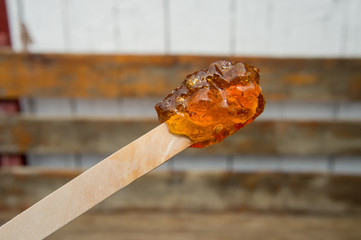 Maple taffy on a stick during sugar shack period