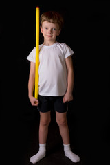 Boy athlete performs exercises with gymnastic stick in the gym