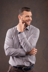 Handsome young bearded man is posing with joy