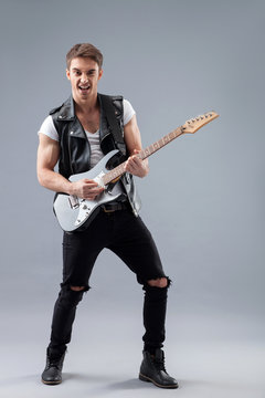 Cheerful male rocker with cool musical instrument