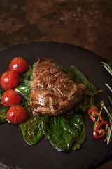 Duck breast grilled on the leaves of basil with tomatoes