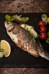 Grilled sea bass with lemon, tomatoes and herbs