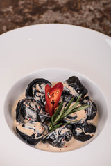 Ravioli with sauce and greens on a plate