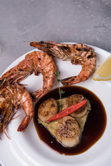 Baked potato and prawns on a plate with lemon