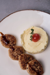 Mashed potatoes and four patties on a plate
