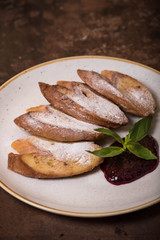 French toast with powdered sugar and jam on a plate