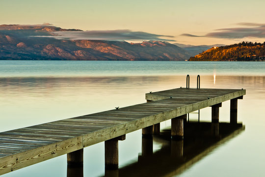 small boat dock on a still mountain lake at sunrise