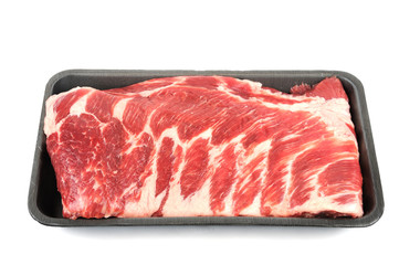 raw pork ribs on white background in plastic container tray