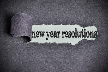 new year resolutions word under torn black sugar paper