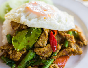 Stir fried pork with curry paste serve with fried egg