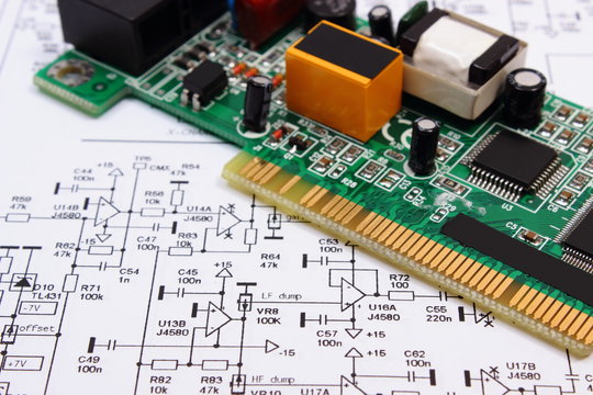 Printed circuit board lying on diagram of electronics, technology