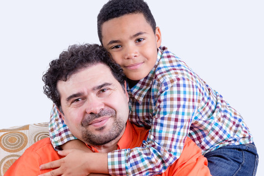 Cheerful child hugging his father on father's day