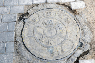 The hatch of urban sewerage with the inscription in the Mongolian language.   Ulaanbaatar, Mongolia