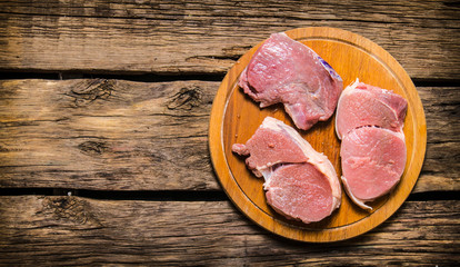 Fresh steaks on an old wooden Board.