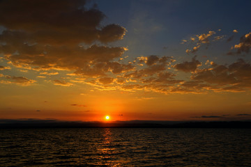Beautiful sunrise with Orange sky and clouds on the lake