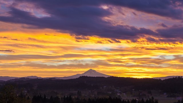 Time lapse movie of colorful sunrise and moving clouds over Happy Valley, Oregon with snow covered Mount Hood early morning