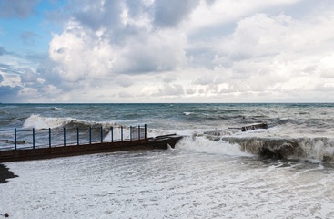 Storm waves roll on the breakwater.