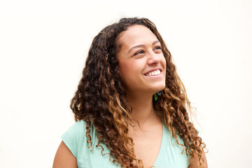 Smiling young woman with curly hair looking away