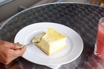 Female hand taking a slice of cake with fork