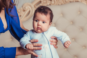 three month old baby in the hands of mother closeup