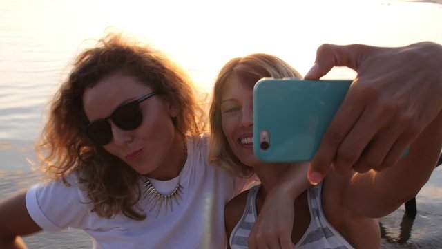 Two Young Girl Friends Taking Selfie at Sunset