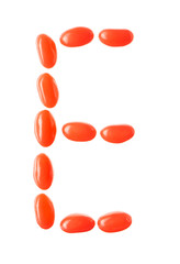 E letter made of red candies isolated on white background